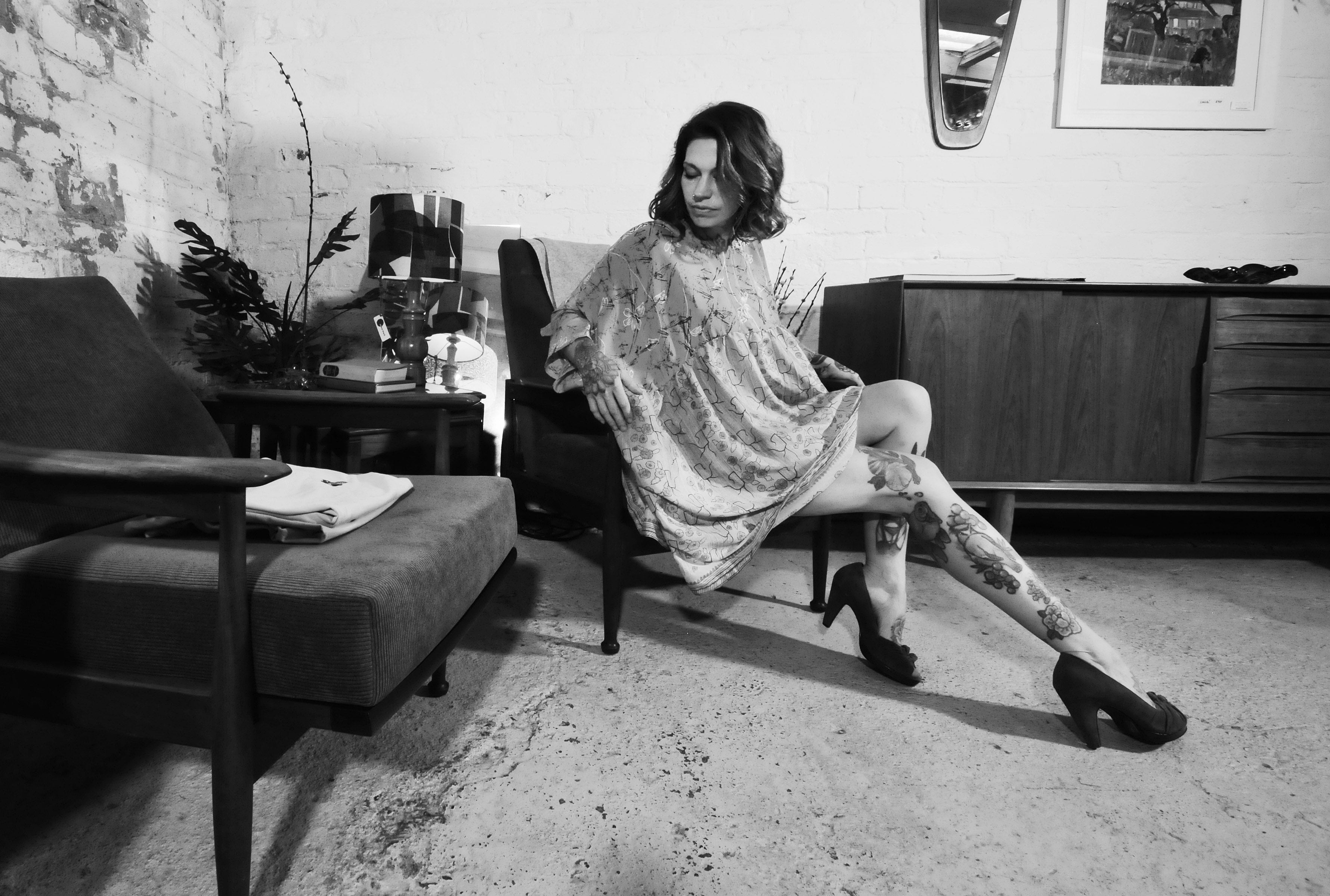 Model sitting on a seventies chair wearing a vintage silk kaftan dress